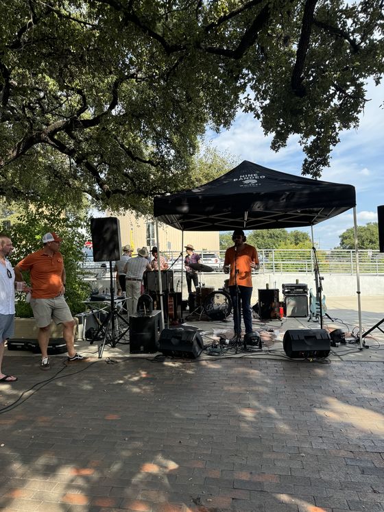 A live band playing on the stage at the tailgate.