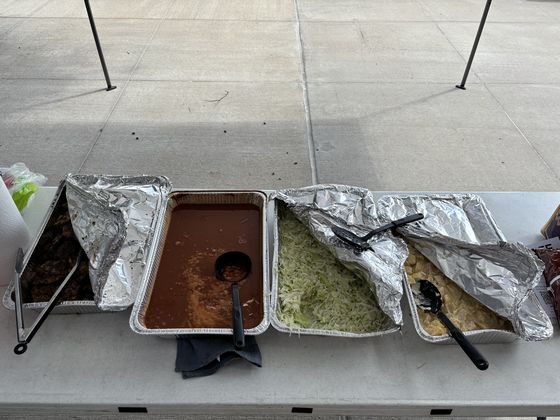 Trays of barbecue, rice and beans on the serving table.