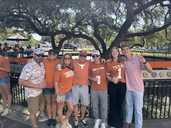 A group of guests together under the oaks before kickoff.
