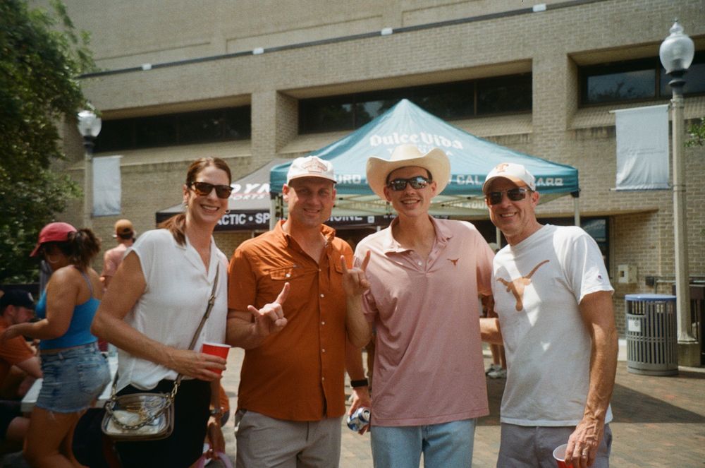 Four guests in front of the Dulce Vida sponsor tent at the tailgate.